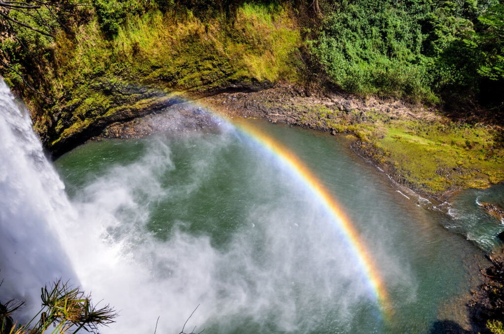 Stunning view of Wailua Waterfall near the island capital Lihue on the island of Kauai, Hawaii. Wailua Falls is a 173 foot waterfall that feeds into the Wailua River. Beautiful rainbow visible.