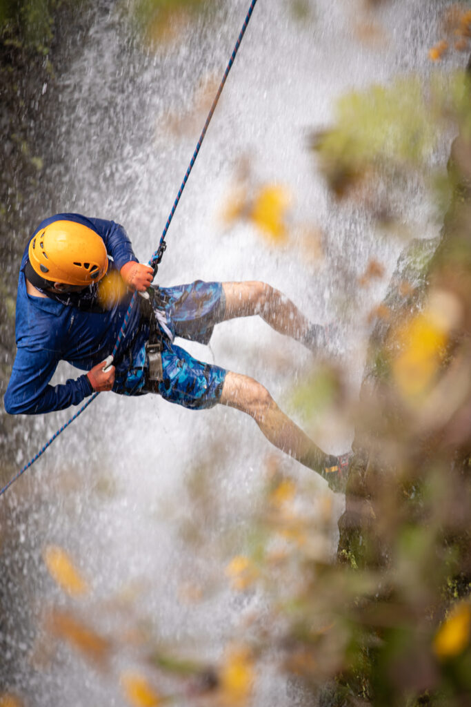 Amateur Man rappelling down a waterfall